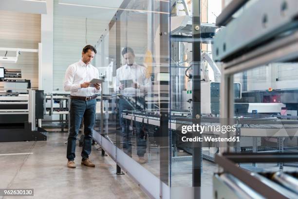 businessman using tablet in modern factory - production line stock pictures, royalty-free photos & images