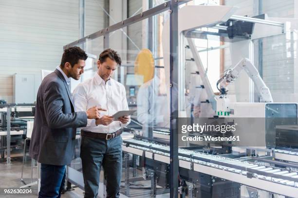 two businessmen with tablet talking in modern factory - factory ipad stock pictures, royalty-free photos & images