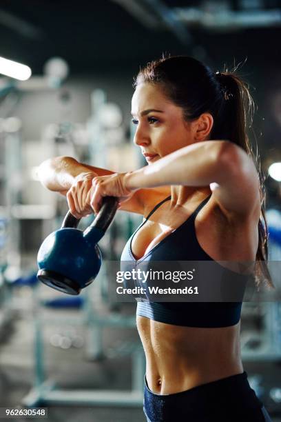 woman exercising with a kettlebell in gym - entrenamiento de fuerza fotografías e imágenes de stock