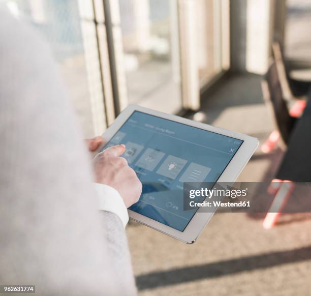 woman using tablet with smart home control functions in office - finger tablet stock-fotos und bilder