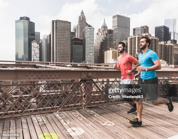 usa, new york city, two men running on brooklyn brige with data on the ground - hunter, new york stock-fotos und bilder