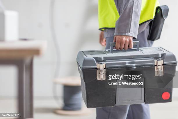 close-up of construction worker carrying tool box - werkzeugkasten stock-fotos und bilder