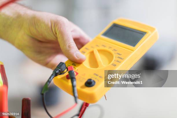close-up of electrician holding voltmeter - voltmeter stock pictures, royalty-free photos & images
