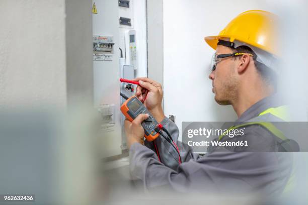 electrician working with voltmeter at fusebox - electrical testing bildbanksfoton och bilder