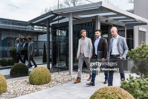 three businessmen walking and talking outside office building - switzerland business stock pictures, royalty-free photos & images