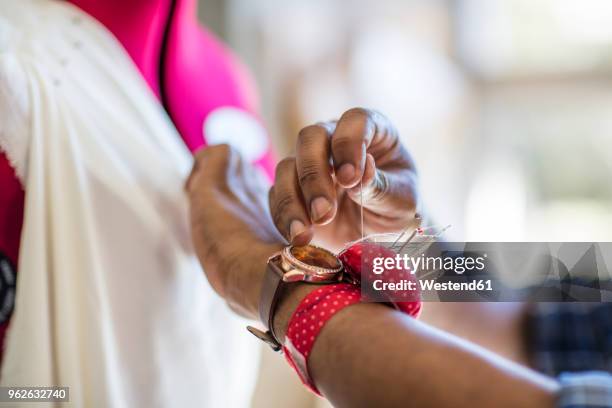 close-up of tailor working on dress in studio - mannequin arm stock pictures, royalty-free photos & images