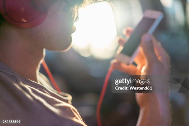 young man in plane with cell phone and headphones - mobile on plane stock-fotos und bilder