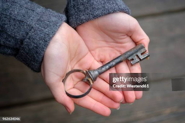 hands holding an old key, close-up - old key stock pictures, royalty-free photos & images