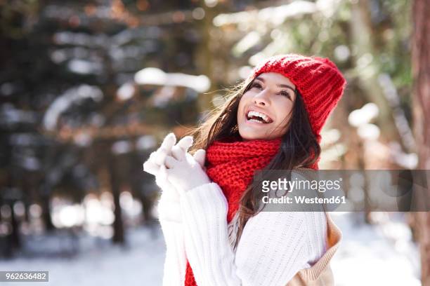 portrait of happy young woman in winter forest - bobble hat stock pictures, royalty-free photos & images