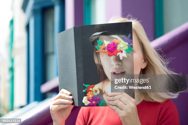 woman covering face with book, reading poetry in the city - mystery book stock pictures, royalty-free photos & images