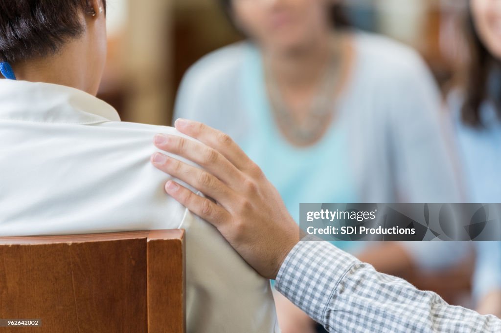 Man comforts woman during counseling session