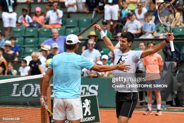 Spain's Rafael Nadal and Serbia's Novak Djokovic hug during an exhibition game during 'Kids Day' on The Philippe Chatrier Court in Paris on May 26 on...