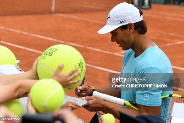 Spain's Rafael Nadal signs autographs at the end of an exhibition game during 'Kids Day' on The Philippe Chatrier Court in Paris on May 26 on the eve...
