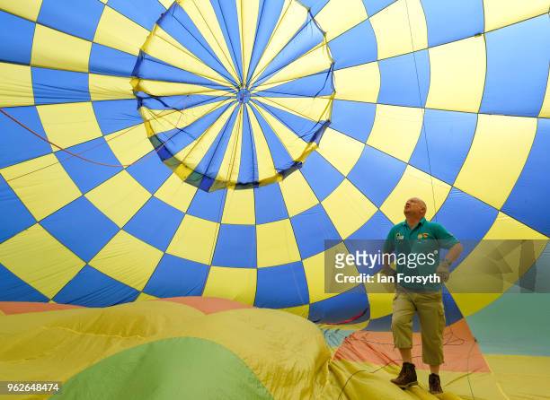 Hot air balloon pilot checks the inside of his balloon as it has cold air blown inside prior to heating during the Durham Hot Air Balloon Festival on...