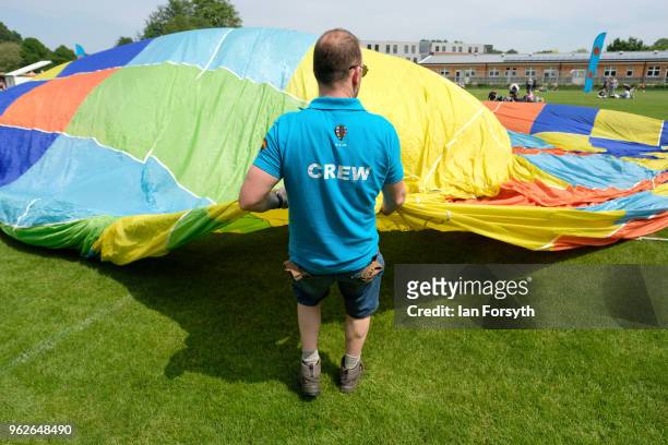 Member of the ground crew lays out the envelope of a hot air balloon during the Durham Hot Air Balloon Festival on May 26, 2018 in Durham, England....