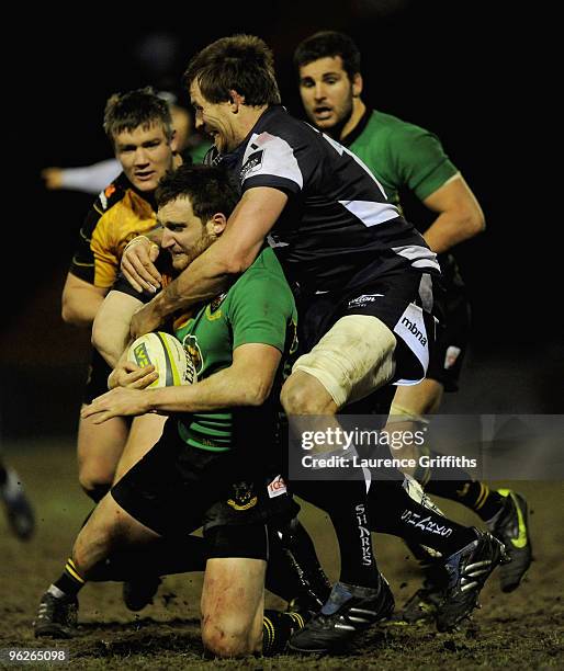 Chris Mayor of Saints is tackled by Dean Schofield and Charlie Hodgson of Sale during the LV Anglo Welsh Cup match between Sale Sharks and...