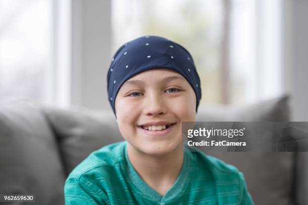 portrait of a 10-year old boy battling cancer in his living room - childhood cancer stock pictures, royalty-free photos & images