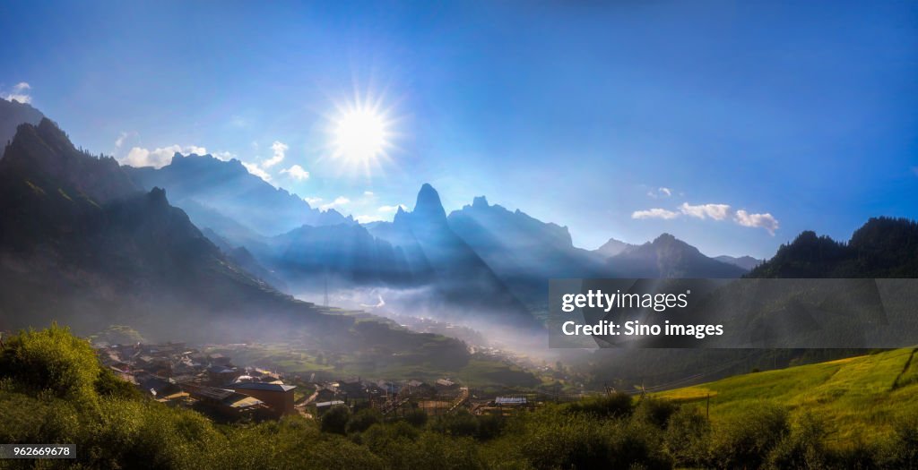 Sun above mountain village,  Gannan, Gansu, China