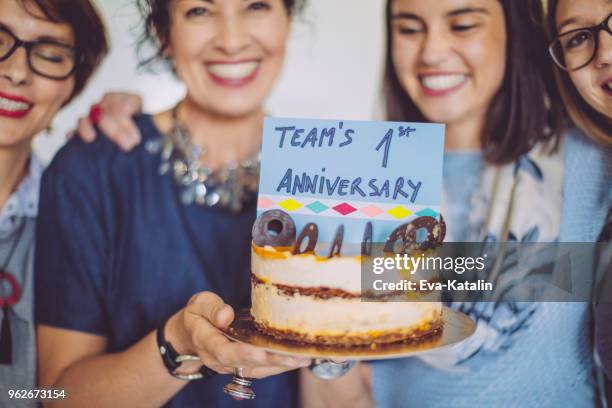 business team celebrating the team's first anniversary - work anniversary stock pictures, royalty-free photos & images