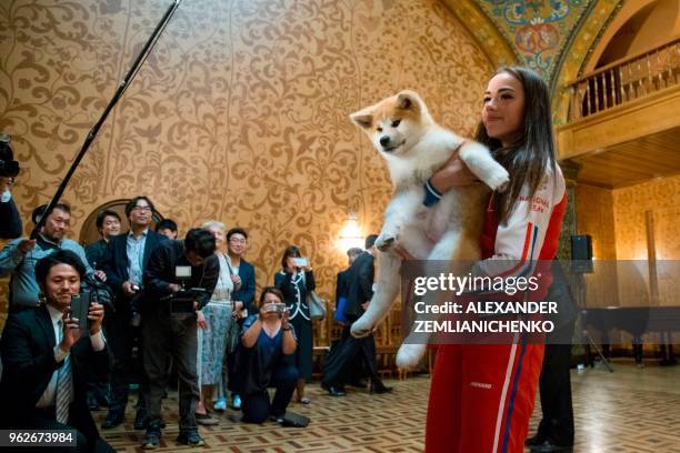 Russian figure skating gold medallist Alina Zagitova holds an Akita Inu puppy named Masaru in her arms after it was presented by Japanese Prime...