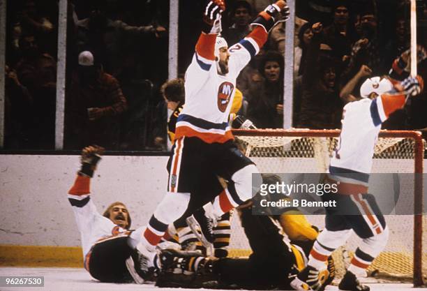 Bobby Nystrom , John Tonelli and Butch Goring of the New York Islanders celebrate Nystrom's overtime game-winning goal in Game 5 of their divisional...