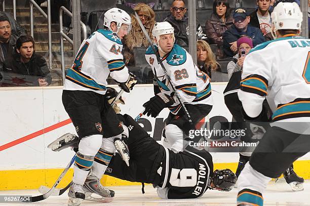 Oscar Moller of the Los Angeles Kings is knocked to the ice by Marc-Edouard Vlasic and Ryane Clowe of the San Jose Sharks on January 19, 2010 at...