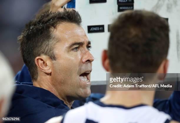 Chris Scott, Senior Coach of the Cats addresses his players during the 2018 AFL round 10 match between the Geelong Cats and the Carlton Blues at...