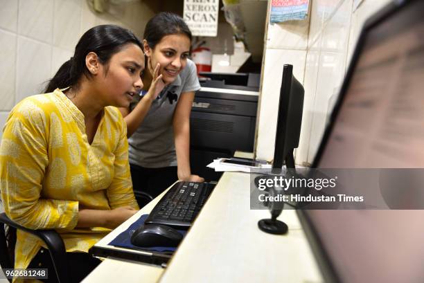 Students check their CBSE's 12th standard examinations results after the declaration of results on website at Paharganj, on May 26, 2018 in New...