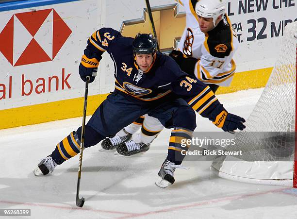 Chris Butler of the Buffalo Sabres skates ahead of Milan Lucic of the Boston Bruins at HSBC Arena on January 29, 2010 in Buffalo, New York.