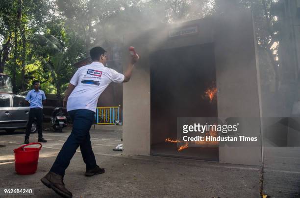 An official of Bluescope fire extinguisher demonstrates the Bluescope Capsule at Central Fire Station in Mahtma Fule Peth, on May 25, 2018 in Pune,...