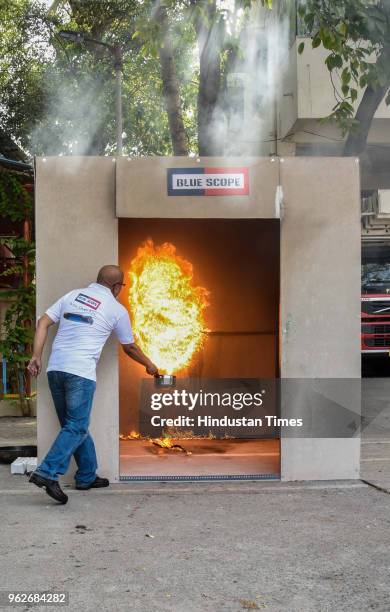 An official of Bluescope fire extinguisher demonstrates the Bluescope Capsule at Central Fire Station in Mahtma Fule Peth, on May 25, 2018 in Pune,...