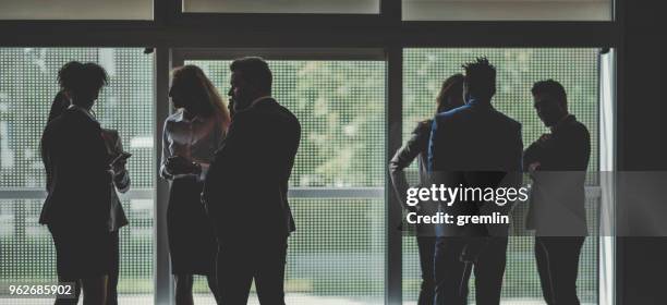 silhueta de empresários no escritório de pé - lobby - fotografias e filmes do acervo