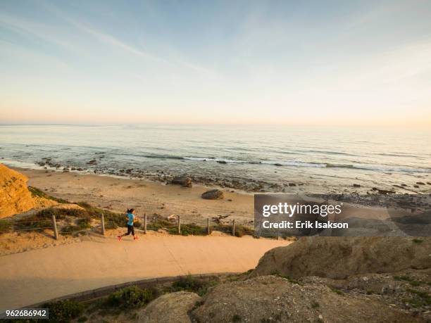 usa, california, newport beach, woman running along footpath - newport beach california stock pictures, royalty-free photos & images