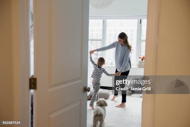 mother and son (4-5) dancing in room - family children dog fotografías e imágenes de stock