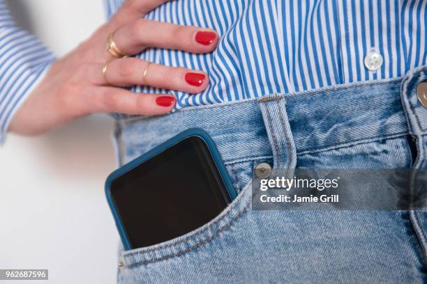 woman with smartphone in jeans pocket - jeans poche photos et images de collection