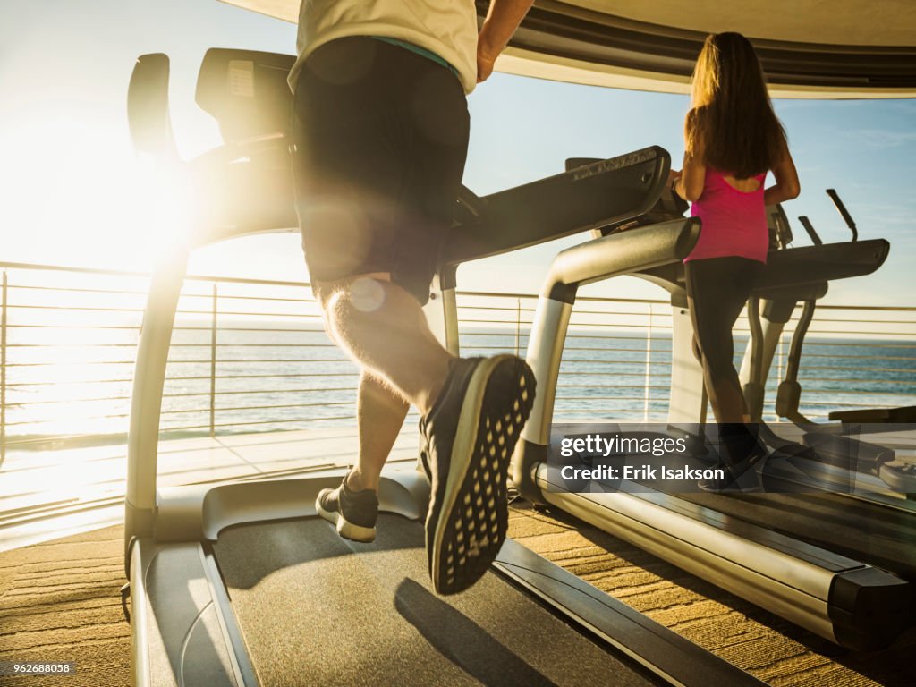 Man and woman exercising on patio over sea