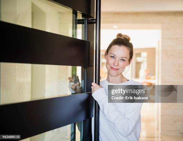 portrait of mature woman at home - entrance fotografías e imágenes de stock