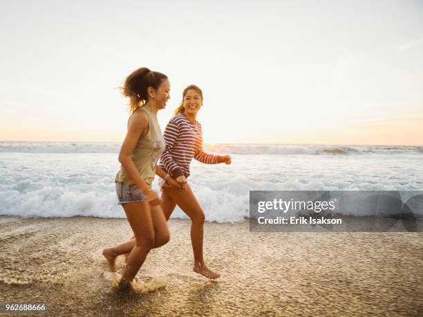 mother and daughter jogging along beach - 家族　日本人　走る ストックフォトと画像