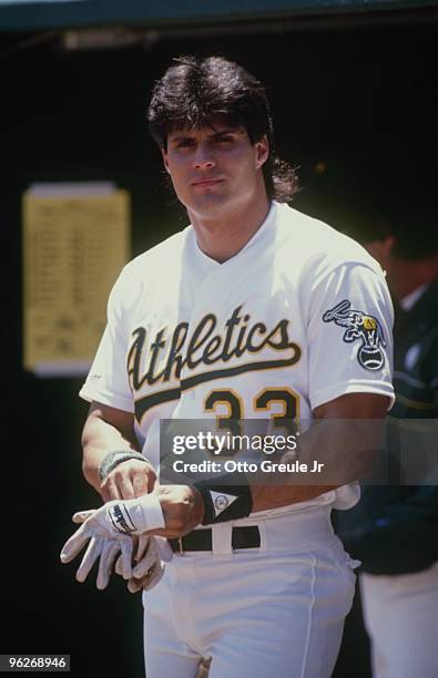 Jose Conseco of the Oakland Athletics stands in the dugout during a season game. Jose Conseco played for the Oakland Athletics