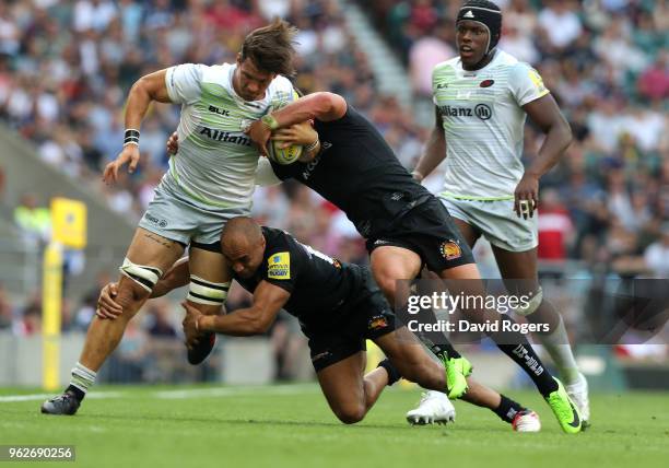 Michael Rhodes of Saracens is tackled by Olly Woodburn and Henry Slade of Exeter Chiefs during the Aviva Premiership Final between Saracens and...