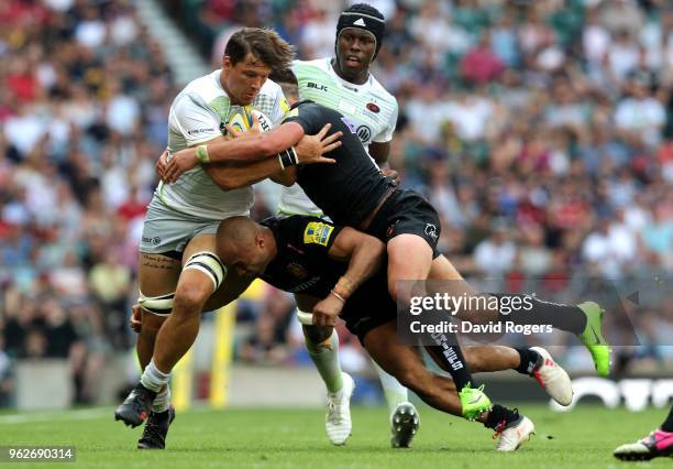 Michael Rhodes of Saracens is tackled by Olly Woodburn and Henry Slade of Exeter Chiefs during the Aviva Premiership Final between Saracens and...