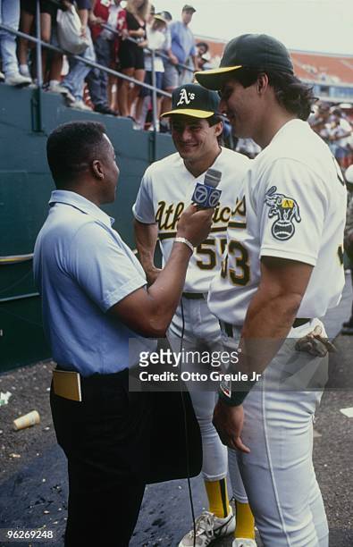 Ozzie Canseco and brother Jose Canseco of the Oakland Athletics talk with a reporter before a 1990 season game at Oakland-Alameda County Coliseum in...