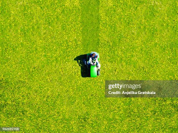 man mowing green field of dandelions, aerial view - gräsklippning bildbanksfoton och bilder