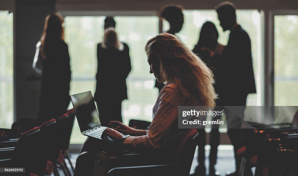 Geschäftsfrau mit Laptop im Konferenzraum