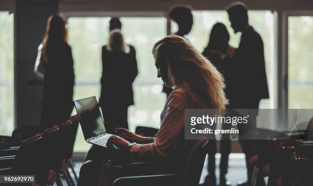 businesswoman using laptop in conference room - journalism stock pictures, royalty-free photos & images