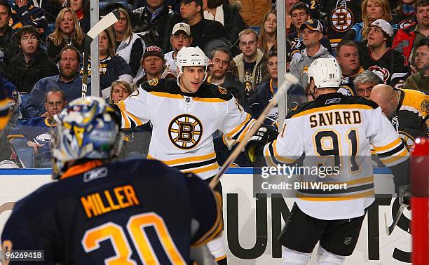 Milan Lucic of the Boston Bruins celebrates his second period goal against Ryan Miller of the Buffalo Sabres with teammate Mark Savard on January 29,...