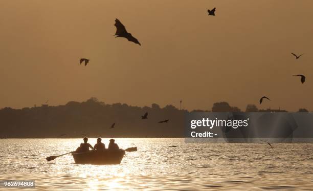 Visitors paddle a boat at Upper Lake as bats fly in Bhopal, in the Indian state of Madhya Pradesh on May 26, 2018.