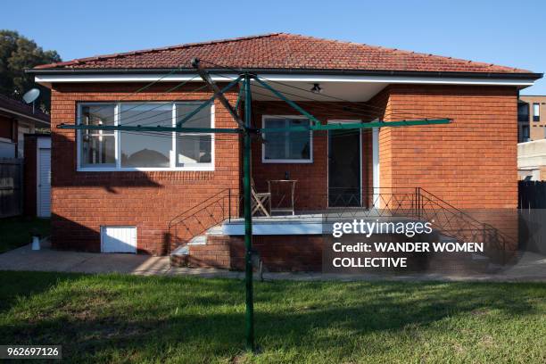 exterior back yard of suburban australian red brick house with hills hoist - brick house stock pictures, royalty-free photos & images