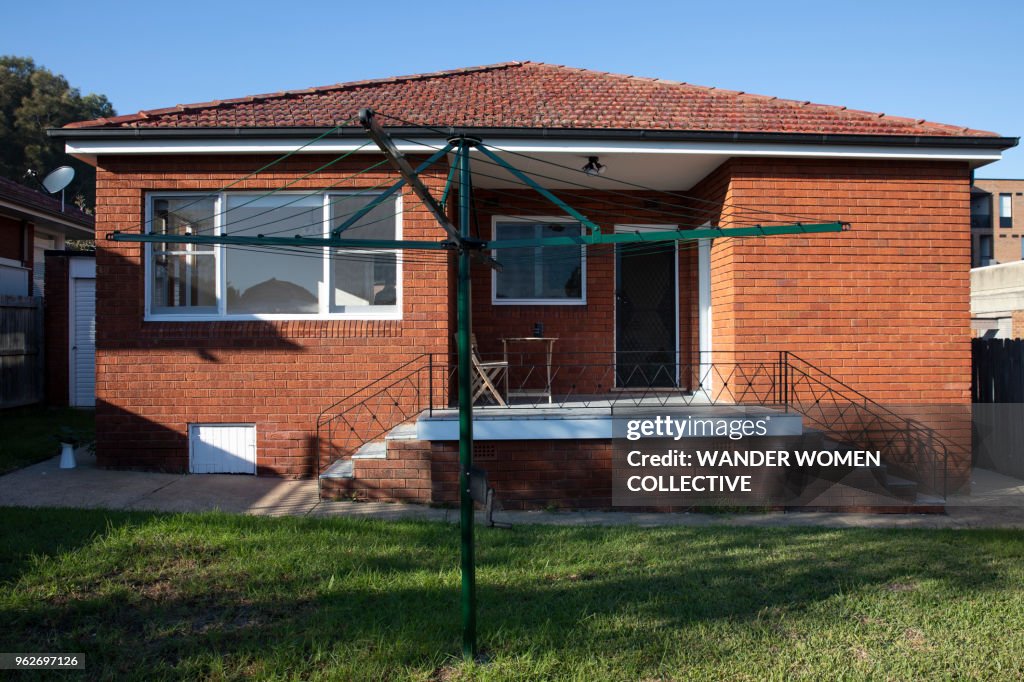 Exterior back yard of suburban Australian red brick house with hills hoist