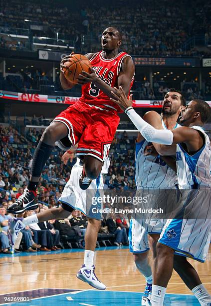 Luol Deng of the Chicago Bulls shoots over Peja Stojakovic and Chris Paul of the New Orleans Hornets on January 29, 2010 at the New Orleans Arena in...